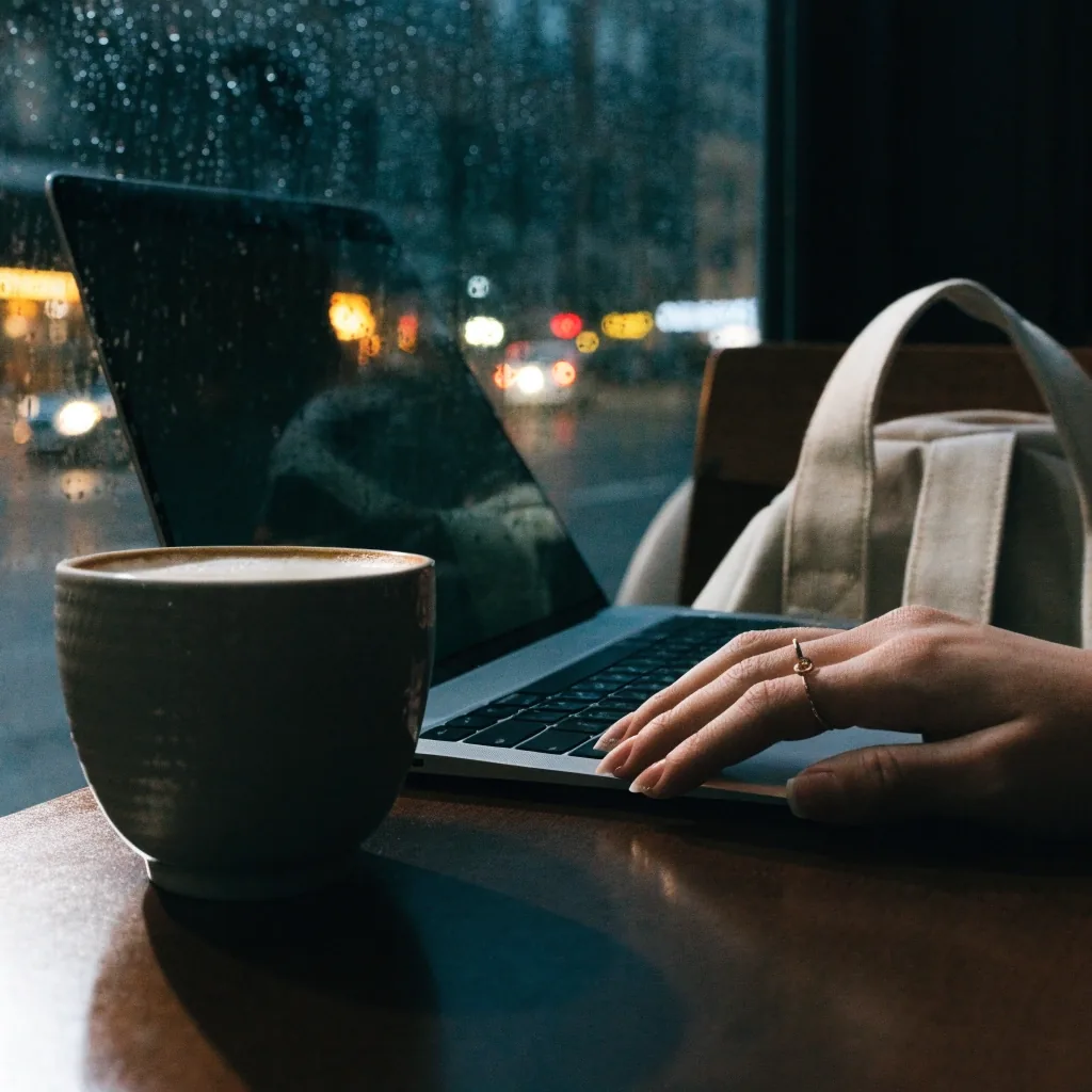 Dim Sydney cafe table at night with laptop edge and coffee cup