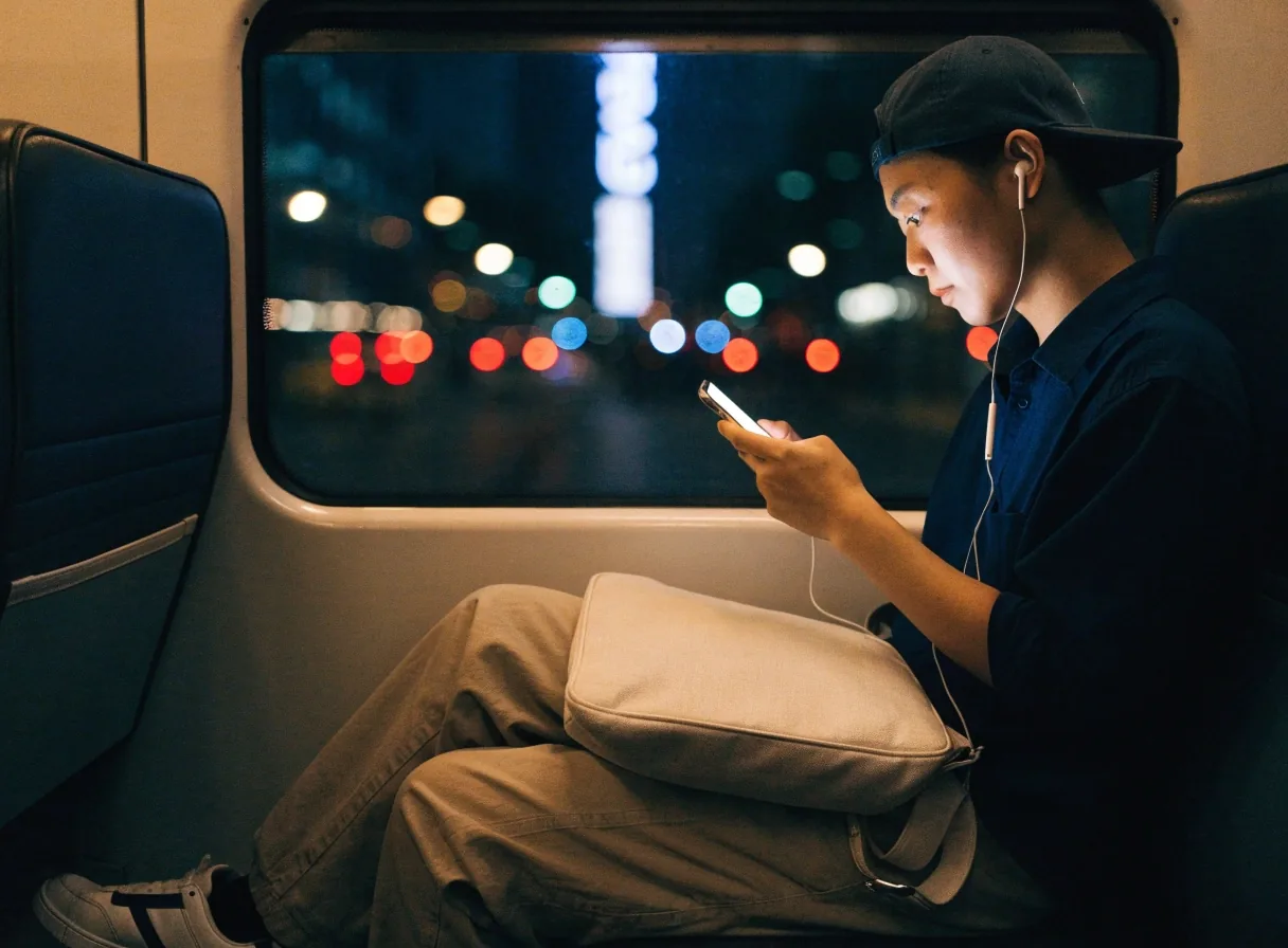 Commuter holding a phone on an evening train